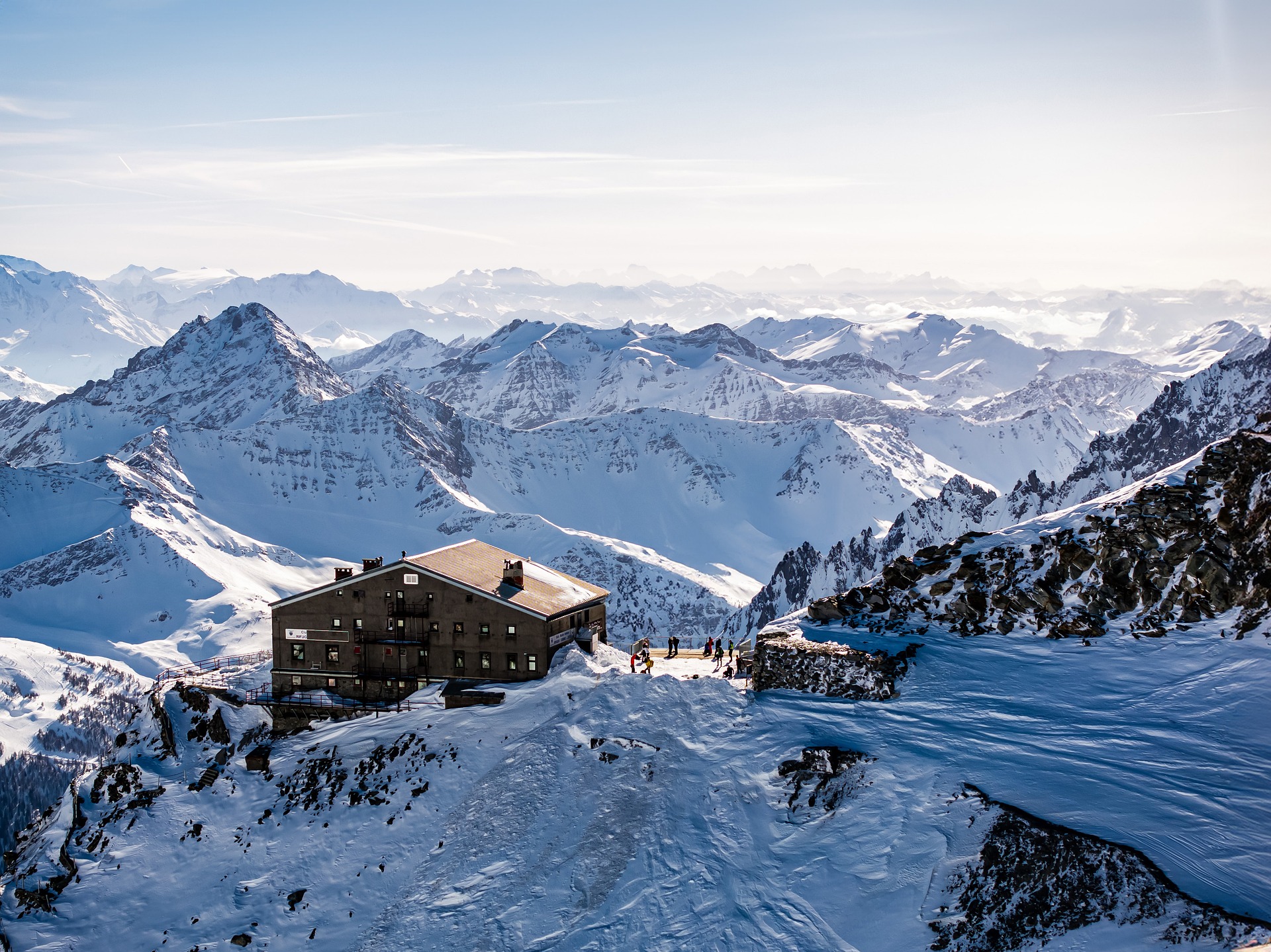 Restaurant auf der Spitze eines Berges, dahinter eine schöne Aussicht auf das Skigebiet